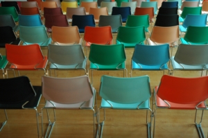 The backs of cheerful colored chairs in a waiting room for a UK visa processing centre, queues can be avoided by etting Butler and BRewer help you with your visa appliction
